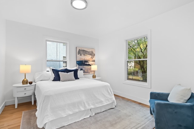 bedroom with wood-type flooring and multiple windows