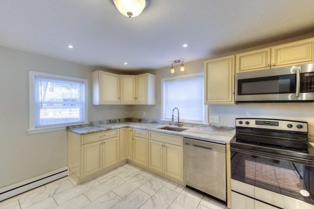 kitchen with a baseboard heating unit, appliances with stainless steel finishes, sink, and cream cabinets