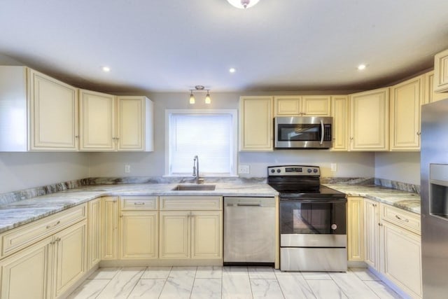 kitchen featuring sink, stainless steel appliances, and cream cabinetry