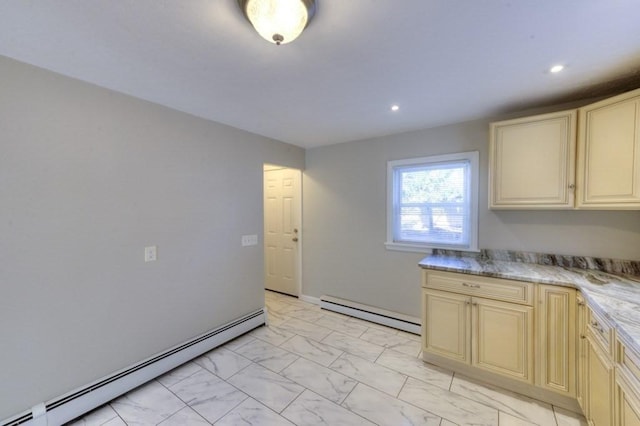 kitchen featuring a baseboard radiator, light stone counters, and cream cabinetry