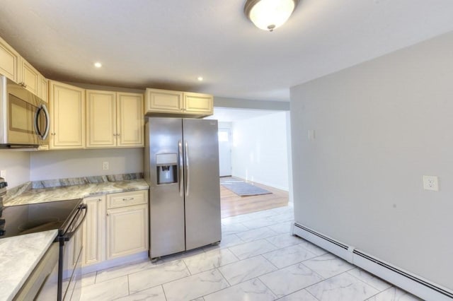 kitchen featuring cream cabinetry, appliances with stainless steel finishes, and a baseboard heating unit