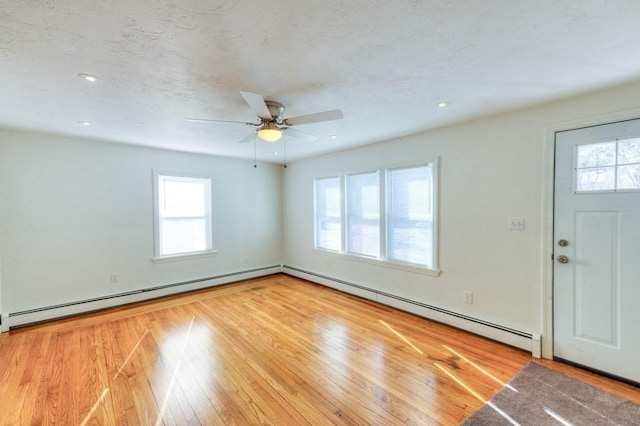 foyer featuring a healthy amount of sunlight, light wood-type flooring, and a baseboard heating unit