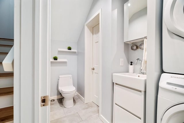 65 Glen Rd Unit H4, Brookline, MA 02445 - bathroom featuring stacked washer / dryer, toilet, vanity, tile patterned floors, and lofted ceiling