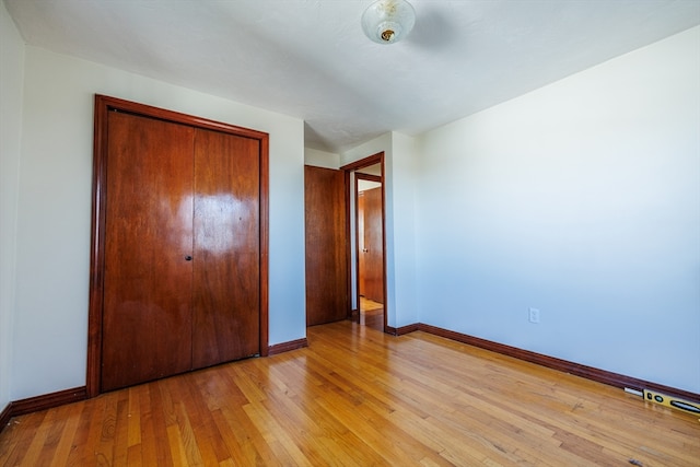 unfurnished bedroom with a closet and light wood-type flooring