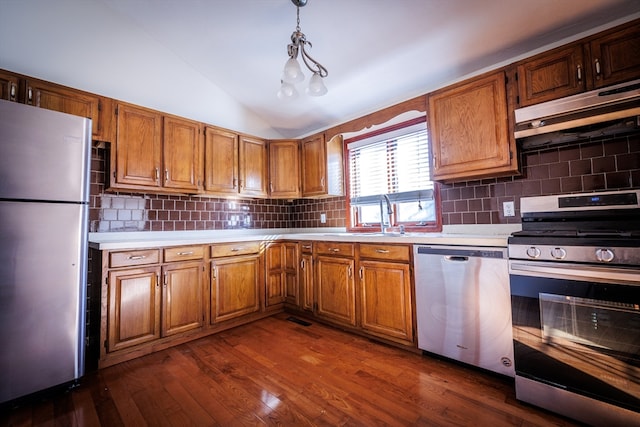 kitchen with dark hardwood / wood-style floors, decorative backsplash, stainless steel appliances, and decorative light fixtures