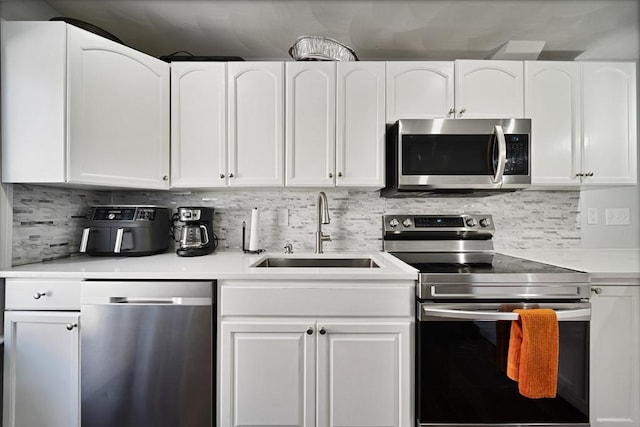 kitchen with white cabinets, backsplash, sink, and stainless steel appliances