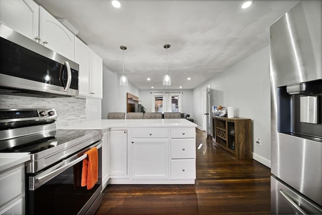 kitchen with dark wood-type flooring, white cabinets, decorative backsplash, kitchen peninsula, and stainless steel appliances