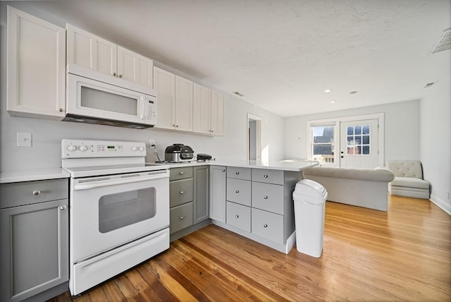 kitchen with kitchen peninsula, light hardwood / wood-style floors, white appliances, gray cabinets, and white cabinets