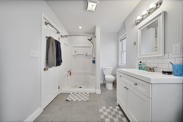 bathroom featuring vanity, tile patterned flooring, toilet, walk in shower, and tasteful backsplash