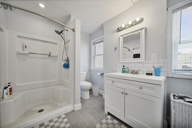 bathroom with tasteful backsplash, a shower, vanity, and toilet