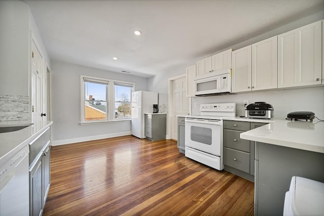 kitchen featuring gray cabinets, white cabinetry, white appliances, and dark wood-type flooring