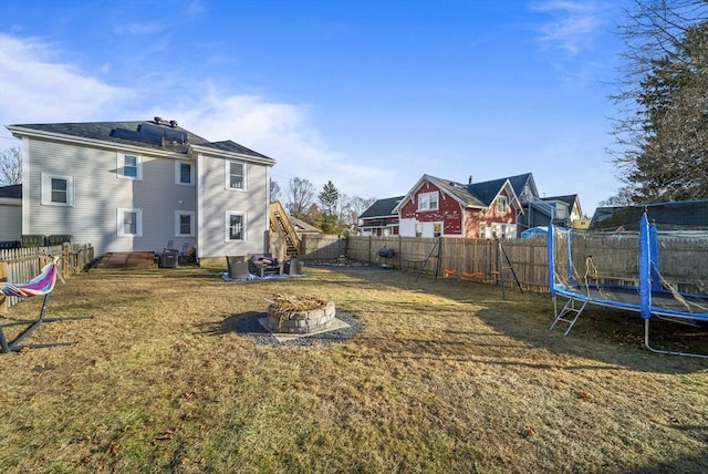 view of yard featuring a fire pit, cooling unit, and a trampoline