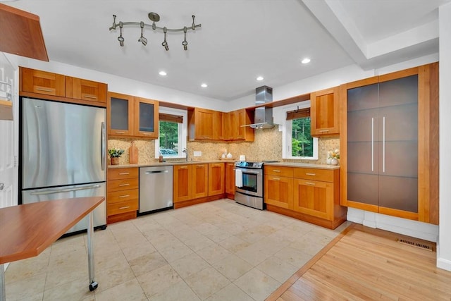 10 Fox Holw Unit 10, Wayland, MA 01778 - kitchen with appliances with stainless steel finishes, wall chimney exhaust hood, light countertops, brown cabinetry, and decorative backsplash