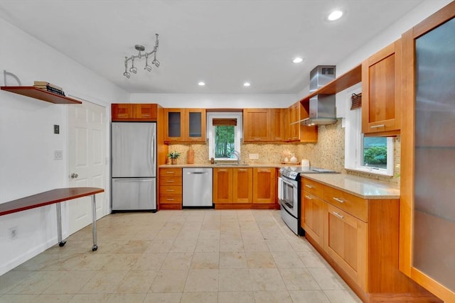 10 Fox Holw Unit 10, Wayland, MA 01778 - kitchen featuring stainless steel appliances, light countertops, wall chimney exhaust hood, tasteful backsplash, and brown cabinets