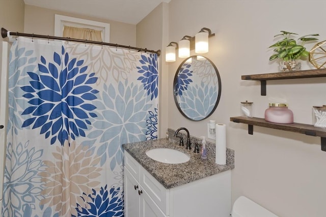 bathroom featuring vanity, toilet, and curtained shower