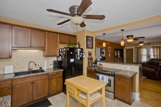 kitchen with decorative backsplash, ceiling fan, a sink, freestanding refrigerator, and electric stove