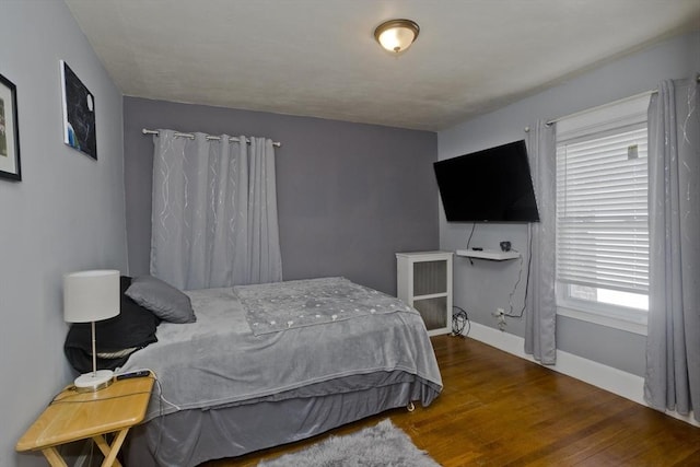 bedroom featuring baseboards and wood finished floors