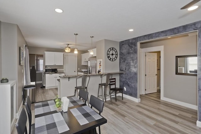 dining room with baseboards, a ceiling fan, recessed lighting, and light wood-style flooring