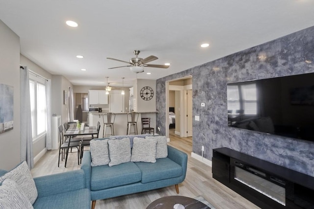 living room featuring baseboards, a ceiling fan, and recessed lighting