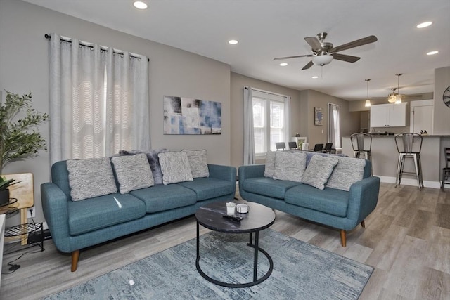living room with recessed lighting, a ceiling fan, and light wood-type flooring