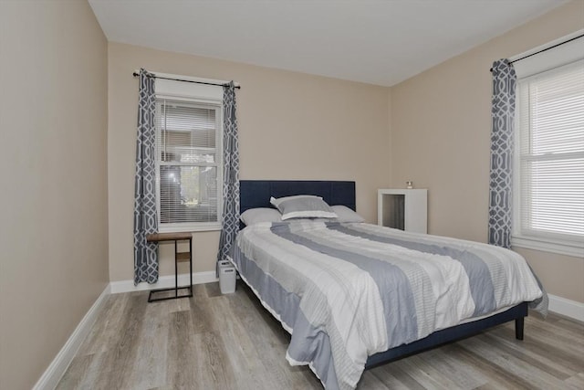 bedroom featuring baseboards and wood finished floors
