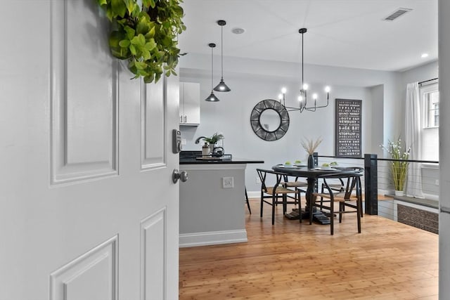 dining room featuring visible vents, baseboards, light wood-style flooring, a notable chandelier, and recessed lighting