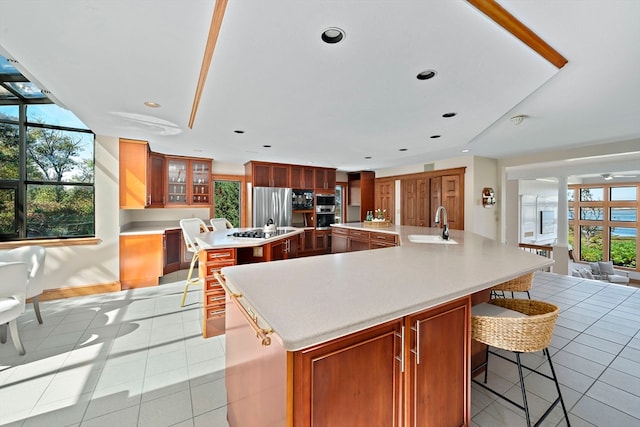 kitchen featuring appliances with stainless steel finishes, sink, a spacious island, and a wealth of natural light