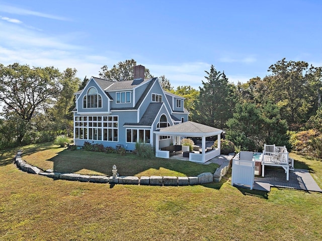 rear view of house featuring a lawn, a gazebo, and a deck