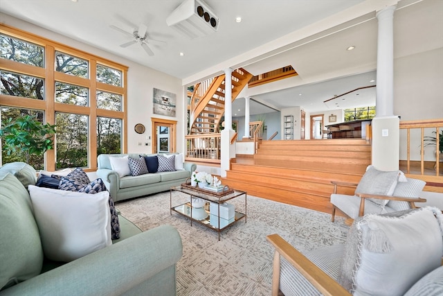 living room with decorative columns, ceiling fan, and light wood-type flooring