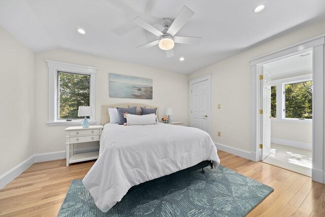 bedroom with light carpet, multiple windows, and baseboard heating