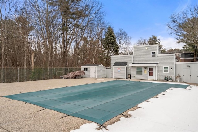 view of swimming pool featuring a shed and a patio