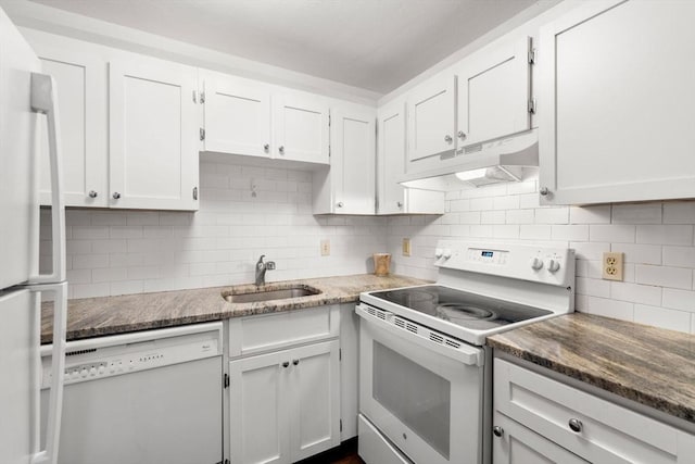 kitchen featuring decorative backsplash, white appliances, dark stone countertops, white cabinets, and sink