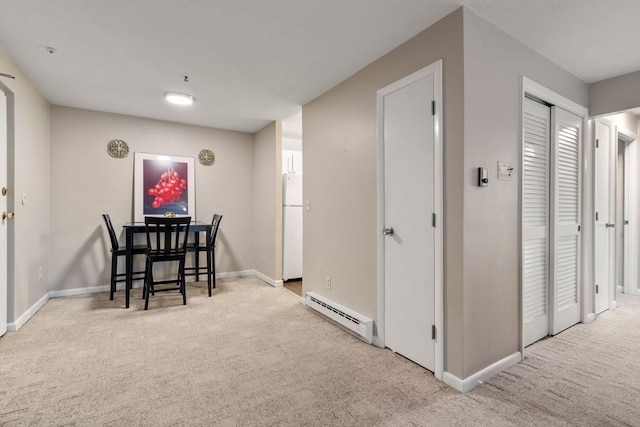 dining area featuring baseboard heating and light carpet