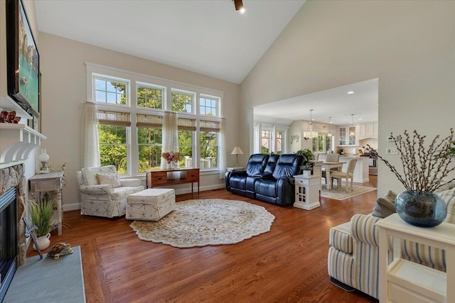 101 Pheasant Hill Cir, Barnstable, MA 02635 - living area with a fireplace, high vaulted ceiling, wood finished floors, and a chandelier