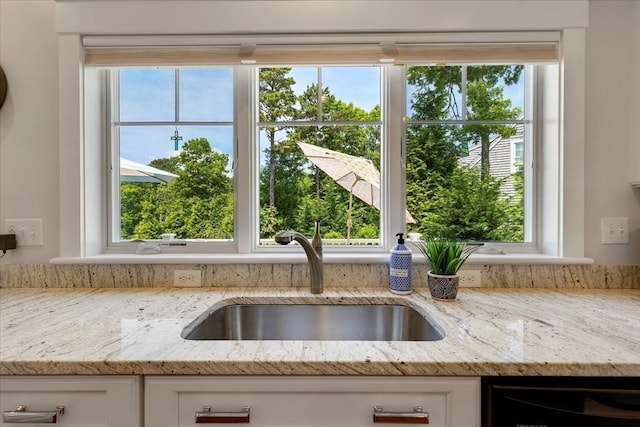 101 Pheasant Hill Cir, Barnstable, MA 02635 - kitchen view of white cabinets, light stone countertops, and dishwashing machine