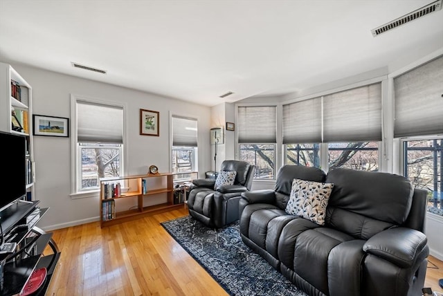 living area with visible vents, baseboards, and light wood finished floors