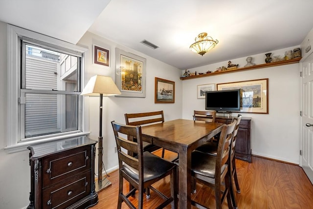 dining space with visible vents, baseboards, and light wood finished floors