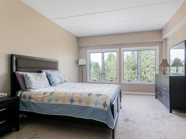 bedroom with visible vents, baseboards, light carpet, and multiple windows