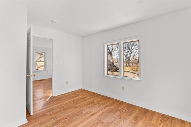 empty room with light wood-type flooring and baseboards