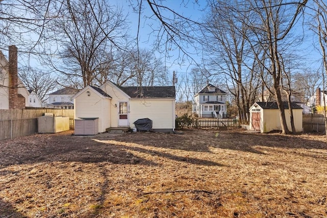 view of yard with an outbuilding, a fenced backyard, and entry steps