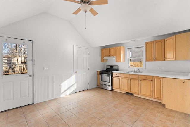 kitchen featuring under cabinet range hood, light countertops, light tile patterned floors, stainless steel gas range, and a sink