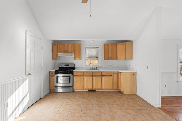 kitchen featuring a sink, light countertops, vaulted ceiling, under cabinet range hood, and gas range