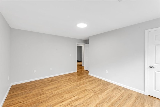 unfurnished room with light wood-type flooring and baseboards
