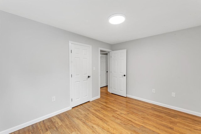 unfurnished bedroom featuring baseboards and light wood-type flooring