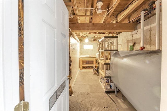 unfinished basement featuring oil tank and carpet floors