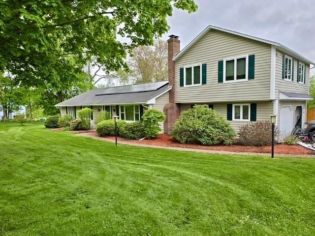 98 Town Farm Rd, Monson, MA 01057 - split level home featuring solar panels, a front yard, a chimney, and a garage