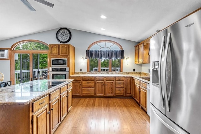 98 Town Farm Rd, Monson, MA 01057 - kitchen with stainless steel appliances, lofted ceiling, brown cabinetry, light stone countertops, and light wood-style floors