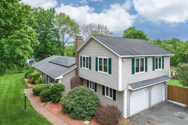 98 Town Farm Rd, Monson, MA 01057 - view of property exterior with a chimney, a garage, driveway, roof with shingles, and roof mounted solar panels