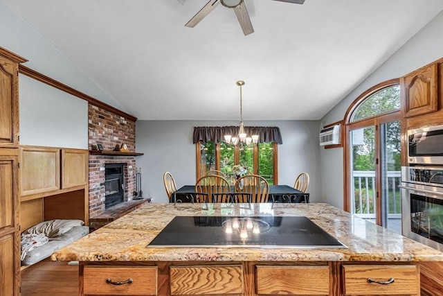 98 Town Farm Rd, Monson, MA 01057 - kitchen featuring vaulted ceiling, stainless steel appliances, a brick fireplace, a chandelier, and a center island with sink