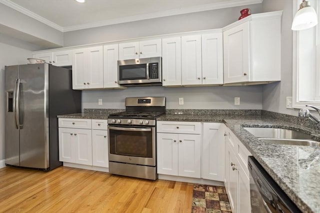 5 Mackenzie Way Unit 5, Haverhill, MA 01832 - kitchen featuring appliances with stainless steel finishes, white cabinets, ornamental molding, light wood-style floors, and dark stone countertops